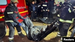 Rescuers remove the body of a person found under the debris of a private house that was hit by a Russian missile strike in Kharkiv on October 29.