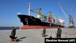 IRAN -- Security guards with their sniffer dogs patrol in front of a cargo ship during the inauguration ceremony of the newly built extension in the port of Chabahar on the Gulf of Oman, southeastern Iran, near the Pakistani border, Sunday, Dec. 3, 2017