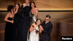 Luana Bajrami (e dyta majtas, rreshti mbrapa) gjatë pranimit të Çmimit Oscar.