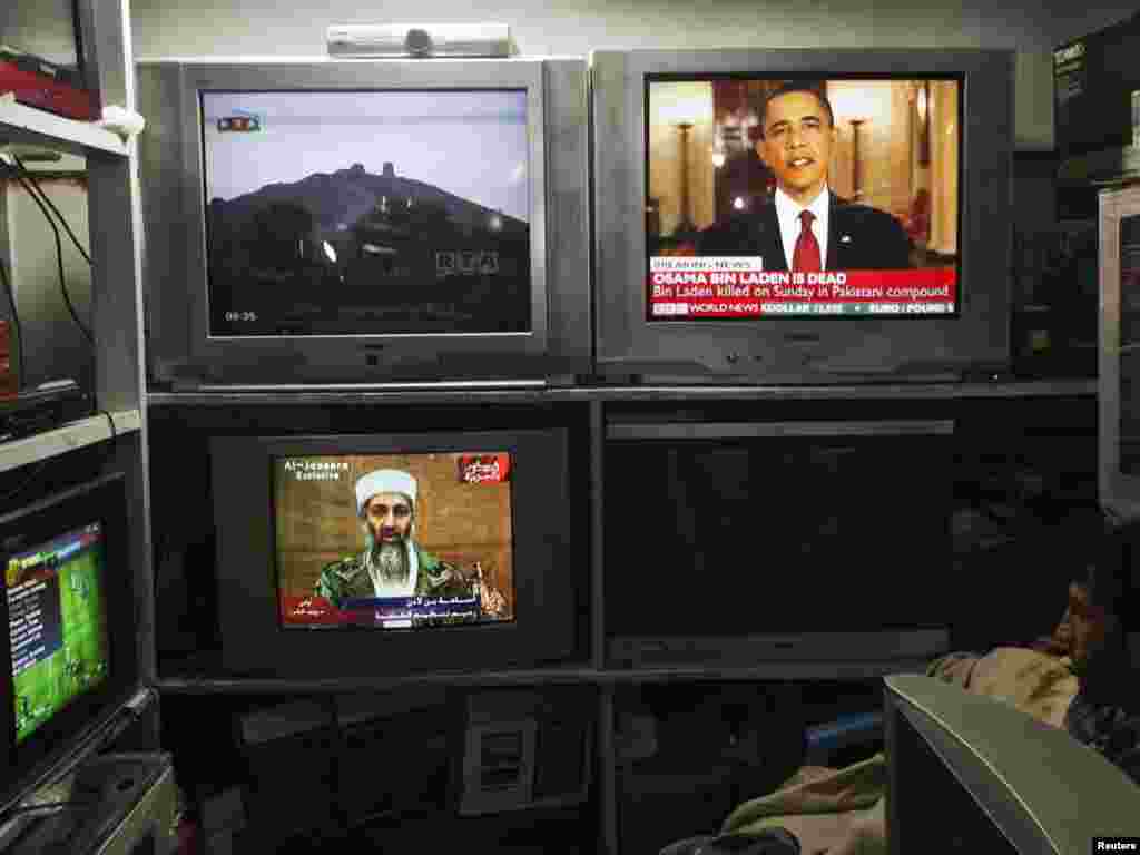 An Afghan shopkeeper watches the news in an electronics shop in Kabul.