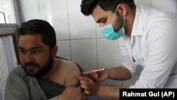 کارمند صحی حین تطبیق واکسین ویروس کرونا در بازوی یک افغان در کابل April 12, 2021