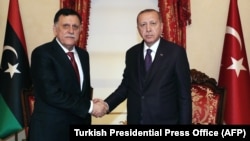 Turkish President Recep Tayyip Erdogan (right) meets with Fayez al-Sarraf, the head of the Tripoli-based Government of National Accord, in Istanbul on December 15.