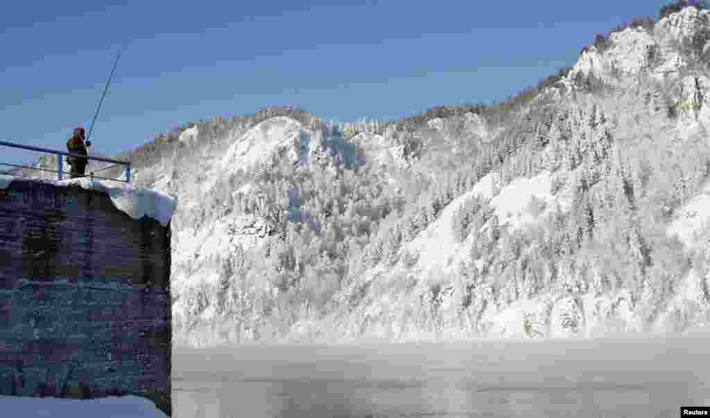 A fisherman stands on a mooring on the Yenisei River, in air temperatures of about minus 20 degrees Celsius during winter in Russia's Siberian town of Divnogorsk. (Reuters/Ilya Naymushin)