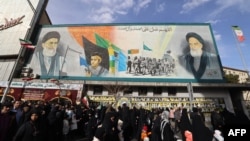 Oamenii trec pe lângă un banner care îi înfățișează pe liderul suprem al Iranului, ayatollahul Ali Khamenei, și pe fostul lider Ruhollah Khomeini. Teheran, 14 ianuarie 2026.