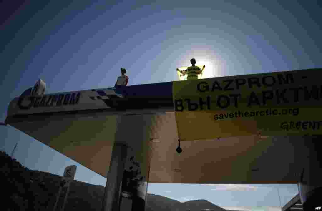 Greenpeace activists stand on the roof of a Gazprom gasoline station in the city of Blagoevgrad, Bulgaria, to protest Russia's holding of around 30 Greenpeace activists detained in the Arctic while drawing attention to a Gazprom oil platform above the so-called ice line in the Arctic. (AFP/Nikolai Doychinov)