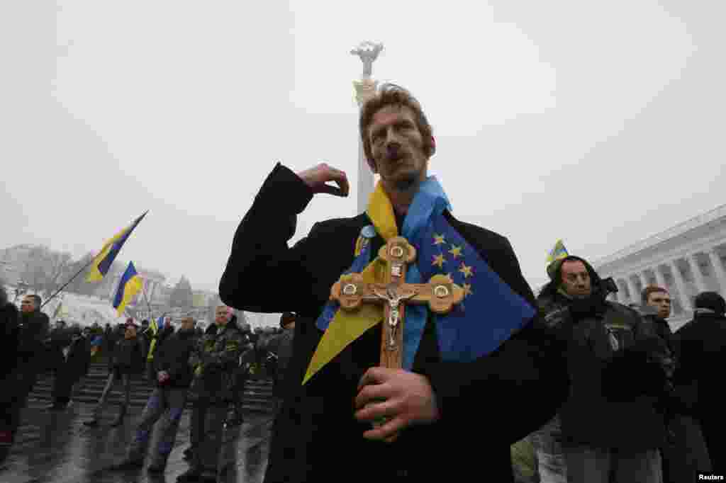 A man crosses himself as pro-European integration protesters gather in Independence Square in central Kyiv on December 12. (Reuters/Alexander Demianchuk)