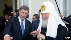 Prim-ministrul estonian, Andrus Ansip (stânga), vorbește cu Patriarhul Kiril al Moscovei și al întregii Rusii, care a sosit la Tallinn, la 14 iunie 2013.