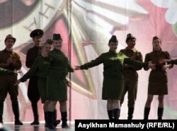 Молодые женщины в военной форме периода Второй мировой войны выступают на сцене в честь празднования Дня Победы. Актау, 9 мая 2012 года. Иллюстративное фото.
