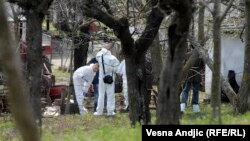 Officers investigate the site of the shootings in the village of Velika Ivanca, about 40 kilometers southwest of Belgrade.