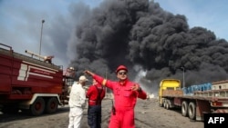 Thick, black smoke rises as rescuers arrive near the source of an explosion near the southern Iranian port city of Bandar Abbason on April 26.