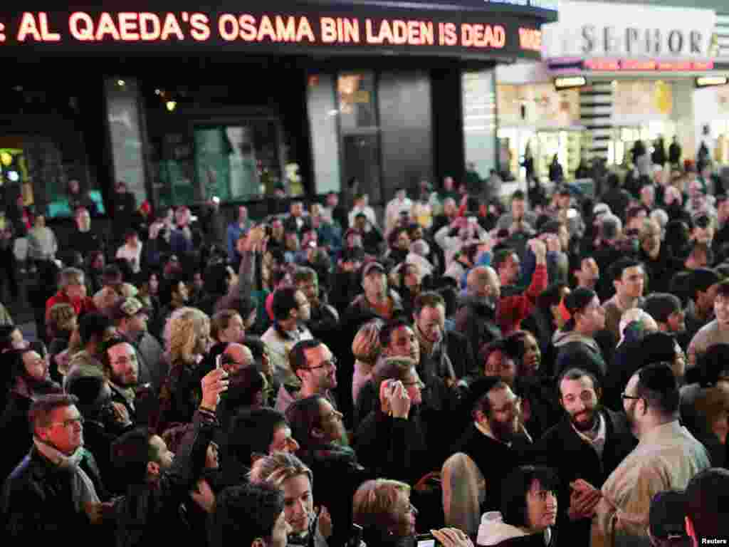 A news ticker displays information on Al-Qaeda leader Osama bin Laden's death in Pakistan as people attend a spontaneous celebration in New York's Times Square.