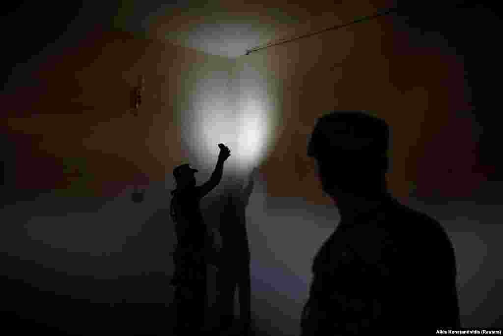 An Iraqi soldier shows Reuters' photographer a surveillance camera used to monitor prisoners inside the compound. 