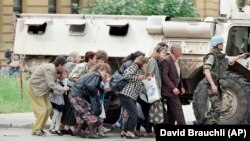 Građani i građanke Sarajeva u zaklonu od snajpera iza vojnog vozila francuskih mirovnih jedinica u centru grada, 6. jun 1995. godine