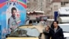 A couple walks past an electoral billboard in a street in Tehran, February 17, 2020