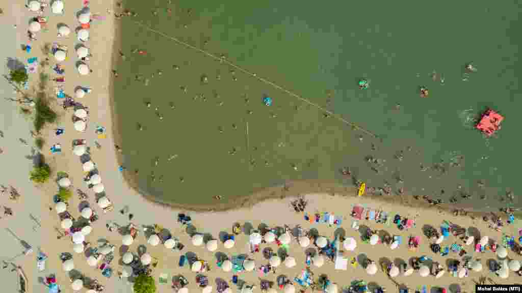 Strandolók kánikulában a budakalászi Lupa-tónál 2020. augusztus 9-én. A Lupán SUP-oktatással, strandröplabdával, koncerttel és dj-vel várják a csobbanni vágyókat éjjel 2-ig