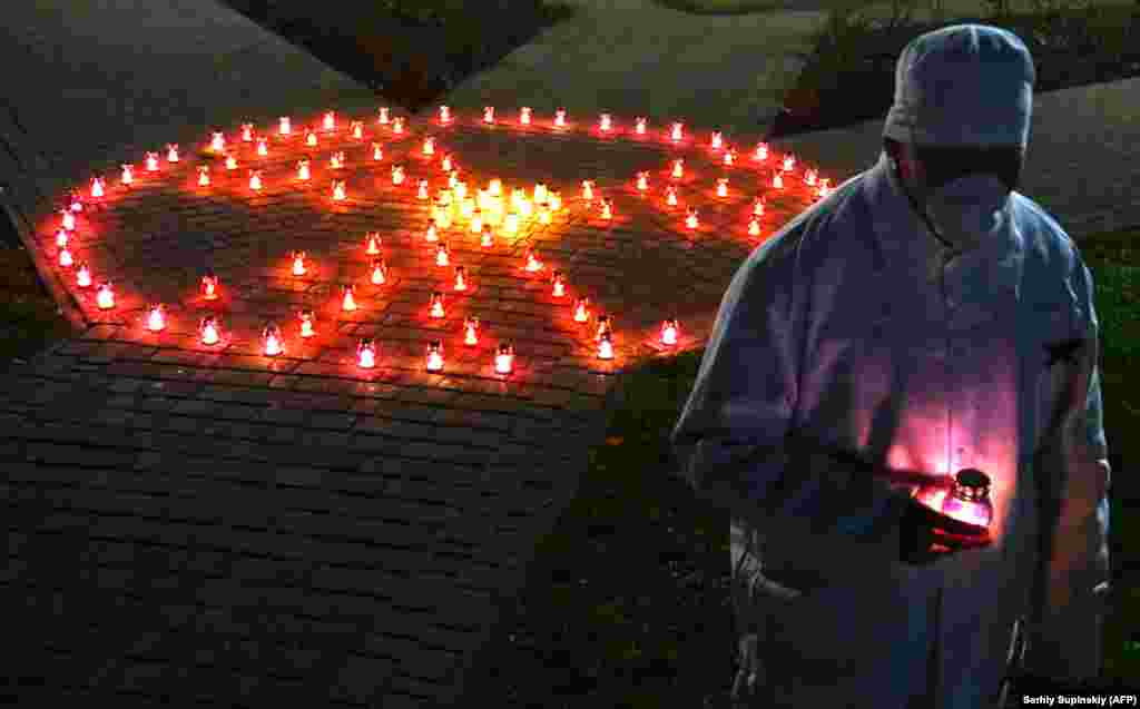 A man pays his respects near a radioactivity sign made out of candles at a monument to victims of the Chernobyl disaster in Slavutych, the Ukrainian city where the power station&#39;s personnel lived, some 50 kilometers from the accident site. (AFP/Sergei Supinsky)