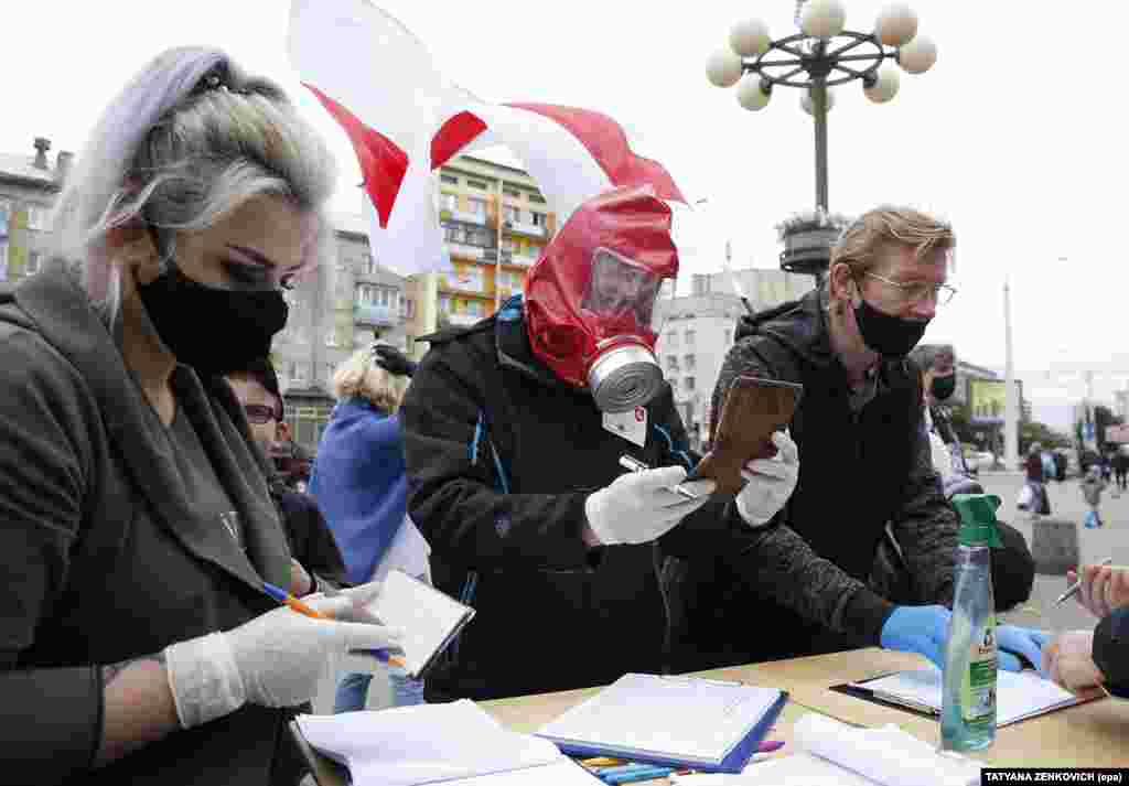 Активисты в защитных масках и перчатках собирают подписи в поддержку потенциальных кандидатов на предстоящих президентских выборах. Минск, 14 июня.