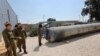 Members of the Israeli military stand next to an Iranian ballistic missile which fell in Israel on the weekend, during a media tour at the Julis military base near the southern Israeli city of Kiryat Malachi on April 16, 2024.