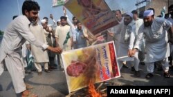 Members of a Pakistani trade union burn posters of U.S. President Donald Trump at a protest in Peshawar on August 30.