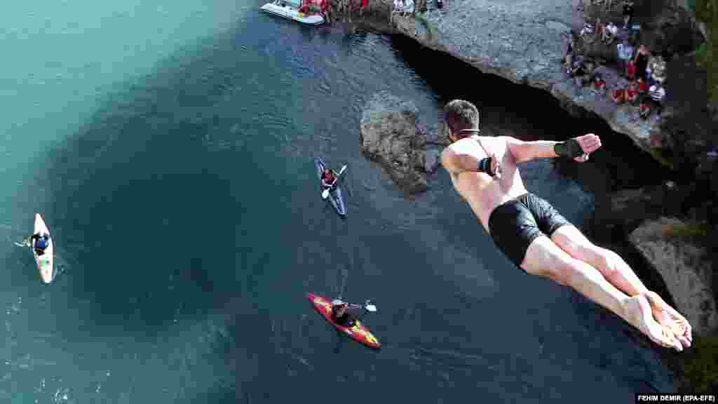 A competitor jumps from the Old Bridge over the Neretva River during the 454th traditional exhibition in Mostar, Bosnia-Herzegovina on July 26. Thirty-two athletes from different nations took part in the event. (epa-EFE/Fehim Demir)