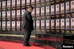 Kim în fața portretelor unor soldați nord-coreeni uciși când luptau alături de armata rusă, în războiul declanșat de Putin împotriva Ucrainei.
