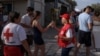 Lucrătorii Crucii Roșii elene împart apă turiștilor la poalele Acropolei, miercuri, 12 iunie. 