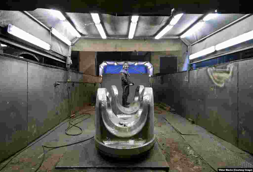 A grinder pauses for a portrait in a foundry in Plzen in the Czech Republic.