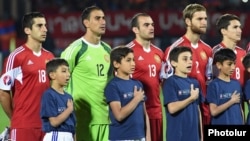 Armenia - Henrikh Mkhitaryan (L) and other Armenia players sing the national anthem before a Euro 2016 qualifying match against Albania, Yerevan, 11Oct2015.