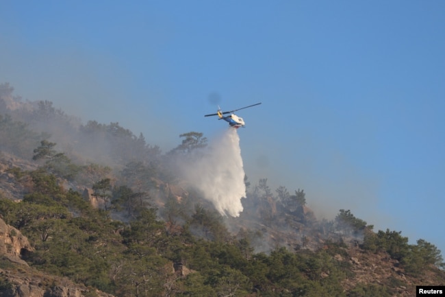 Një helikopter zjarrfikës hedh ujë ndërsa një zjarr i madh po digjet pranë Ierapetrës, në ishullin e Kretës, Greqi, 3 korrik.