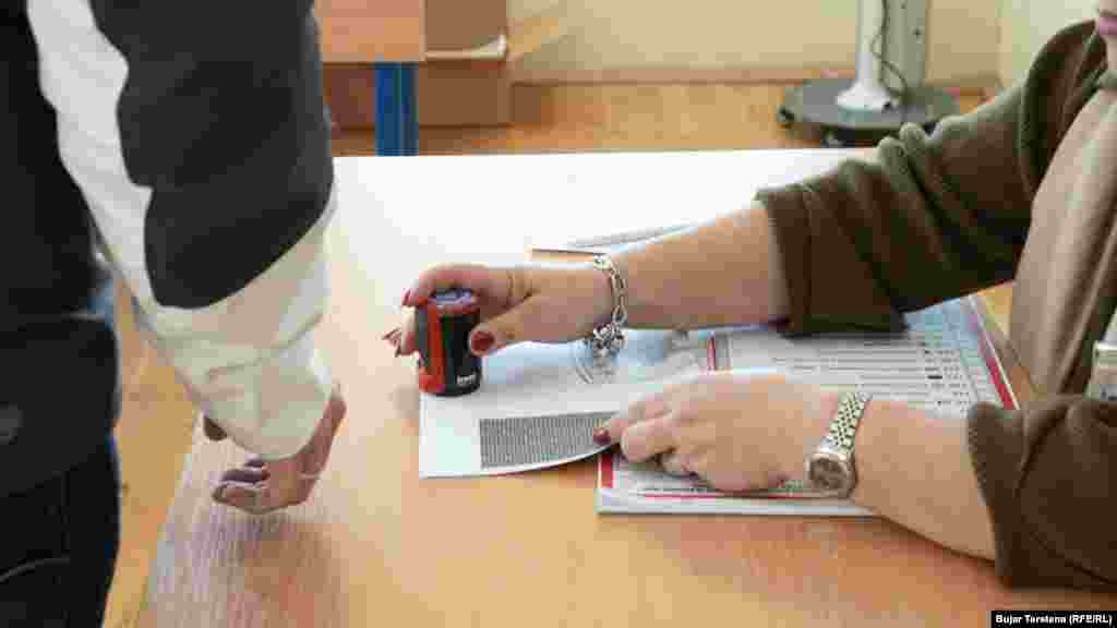 Një zyrtare zgjedhore e vulos një fletëvotim në zgjedhjet e parakohshme parlamentare në një qendër votimi në Mitorvicën e Veriut.