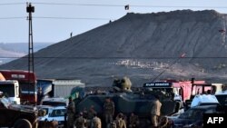 جنود أتراك ينظرون الى مسلحي تنظيم "داعش" وهم يرفعون علمهم على جبل مطل على كوباني
