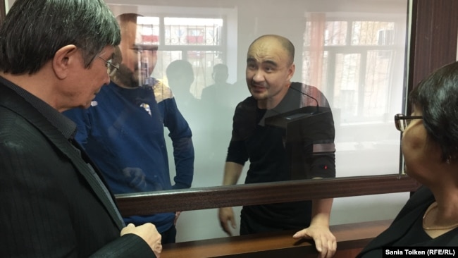 Гражданские активисты Макс Бокаев (второй справа) и Талгат Аян (второй слева) на суде по их делу. Атырау, 18 ноября 2016 года.