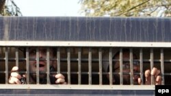 FILE: Terror suspects look out of a prisoners van as they are brought to a court in eastern Pakistan.