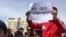 Участник митинга держит плакат с надписью: «Продать землю — продать родину»