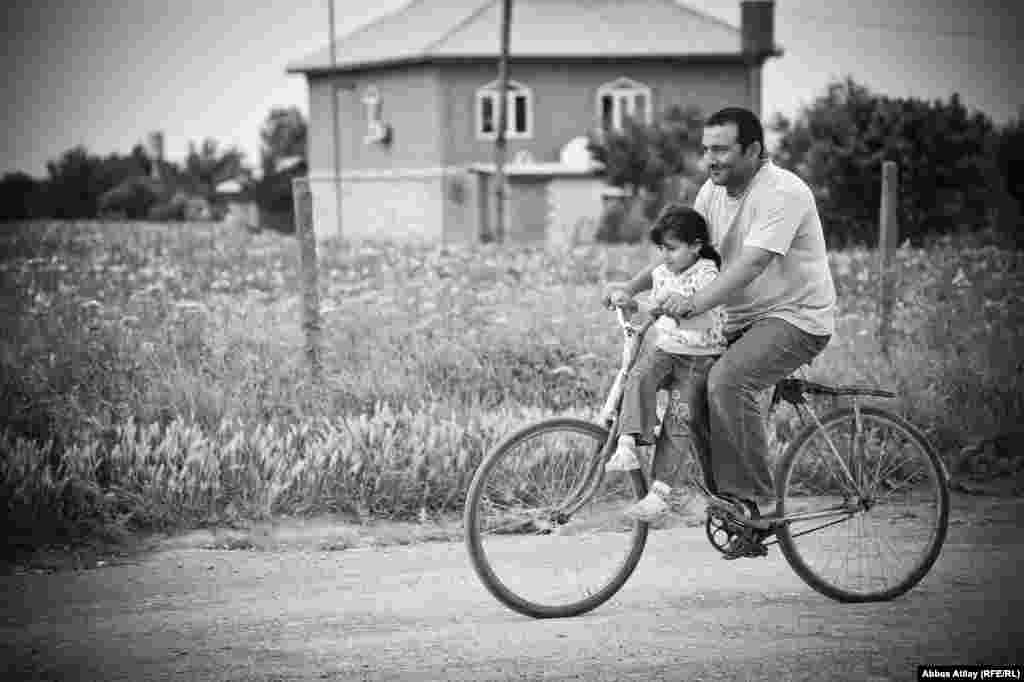 Cəlilabadda ata qızını velisipedlə gəzdirir.