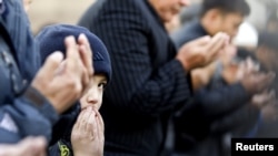 Люди молятся в центральной мечети Алматы.