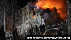 Rescue teams work at the site of an apartment building in Kharkiv that was struck by a Russia missile late on March 7.