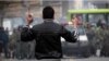 A protester holds stones as he faces off against security forces in Tehran in December 2009