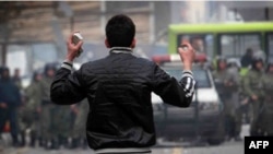 A protester holds stones as he faces off against security forces in Tehran during antigovernment protests on December 27. Mohammad Amin Valian has been sentenced to death for similar behavior during the rallies.