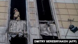 A firefighter looks out from inside the fire-gutted shopping mall in Kemerovo, March 29, 2018