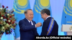 Президент Казахстана Нурсултан Назарбаев награждает орденом «Барыс» руководителя своей администрации Адильбека Джаксыбекова. Астана, 13 декабря 2016 года.