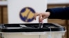 Një qytetare duke votuar në një qendër votimi në Kosovë.