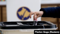 Një votuese duke hedhur votën e saj në një kuti votimi, në Prishtinë. Fotografi nga arkivi.
