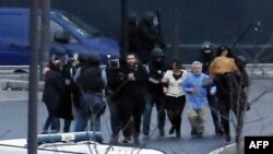 Спецпризначенці виводять врятованих заручників із крамниці під час штурму, 9 січня 2015 року