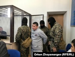 Қарулы айдауылдар айыпталушы Аманжол Жансеңгіровті сот залына әкелген сәт. Нұр-Сұлтан, 22 қазан 2019 жыл.
