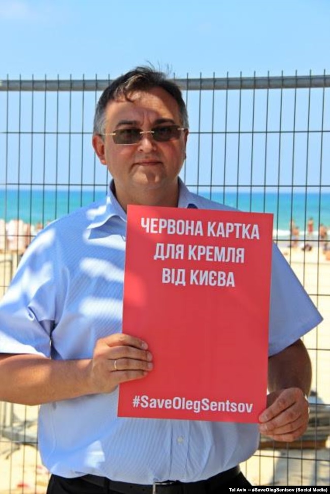 Один из участников акции в Тель-Авиве. На плакате написано "Красная карточка из Киева для Кремля"