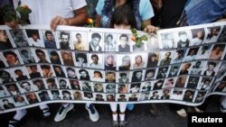 Devojčica drži poster sa fotografijama žrtava Srebrenice tokom ispraćaja kolone sa posmrtnim ostacima 409 žrtava genocida, Sarajevo, 9. jul 2013.