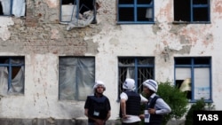 OSCE observers inspect buildings damaged during shelling in the Donetsk region earlier this week. A recent uptick in violence in the area saw a patrol from the OSCE Special Monitoring Mission shot at on May 27