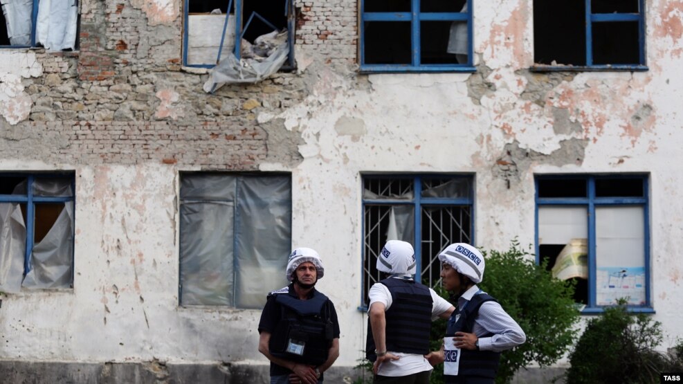Vëzhguesit e OSBE-së duke e shikuar një ndërtesë të dëmtuar nga sulmet me predha në rajonin Donjeck më 26 maj 