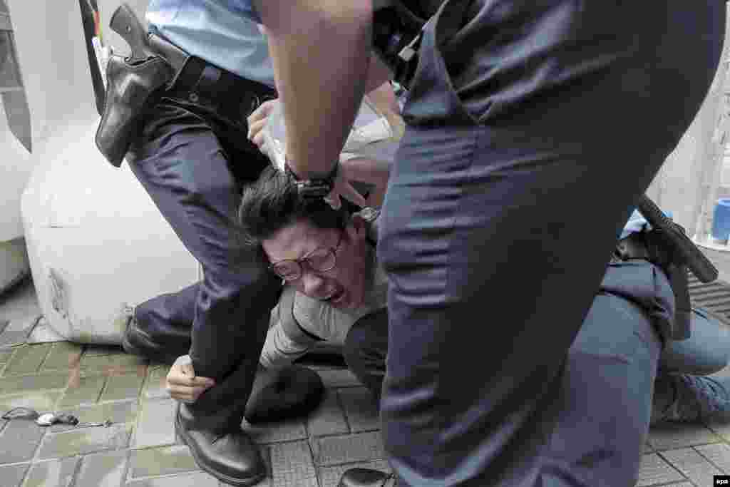 Nathan Law, the chairman of the political party Demosisto, a party advocating democratic self-determination and autonomy for Hong Kong, is subdued by police after trying to cross into a security area where Chinese state leader Zhang Dejiang resides during his stay in Hong Kong. (epa/Demosisto/handout photo)